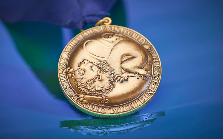 Schreyer Scholars Medal on a reflective surface